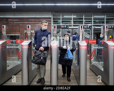 Moskau. Russland. 29. Oktober 2020. Passagiere passieren automatische Drehkreuze an der Moskauer U-Bahn-Station. Auf den Gesichtern der Menschen, Schutzmasken Stockfoto