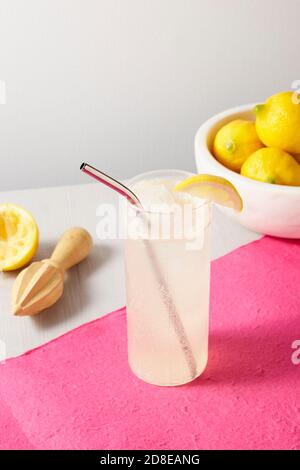 Limonade mit Zitronen auf rosa Hintergrund Stockfoto