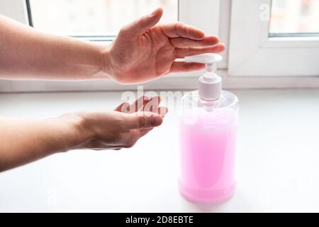 Weibliche kaukasische Hand drücken Desinfektionsflasche für Arme desinfizieren Stockfoto