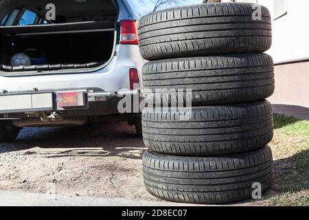 Vier Sommerreifen sind neben geöffneten Kofferraum von suv-Auto, saisonalen Reifenwechsel, niemand Stockfoto