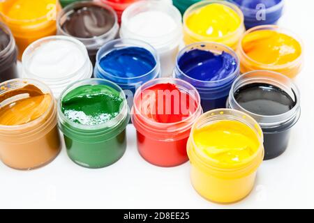 Kunststoffgläser mit farbigen Farben auf weißem Hintergrund Stockfoto