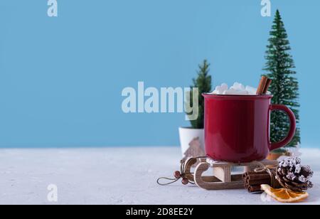 Winter Heißgetränk, Kakao mit Marshmallows und Zimt oder würzige heiße Schokolade in roter Tasse. Frohe Weihnachten. Festlicher Vintage-Hintergrund. Speicherplatz kopieren für Stockfoto