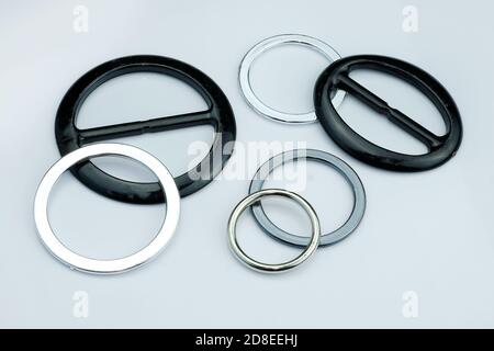 Spritzgussfittings aus Kunststoff für den Gürtel von Kleidern oder Röcken. Schwarz und grau Kunststoff Schnalle für Kleidung. Kunststoffbeschläge auf grauem Hintergrund. Stockfoto