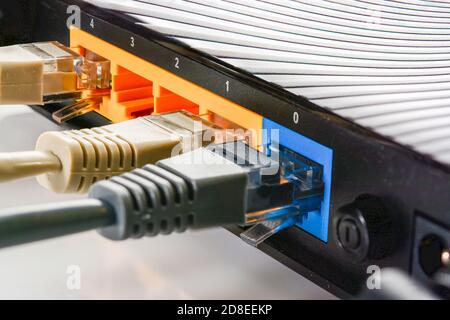 Internet-Router für Zuhause mit drei Kabeln mit RJ-45-Anschlüssen, Internetverbindung. Konzept Heimnetzwerk, Nahaufnahme. Stockfoto