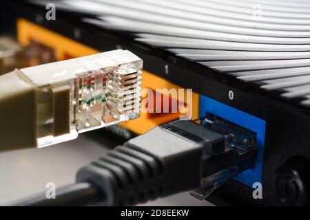 Internet-Router für Zuhause mit drei Kabeln mit RJ-45-Anschlüssen, Internetverbindung. Konzept Heimnetzwerk, Nahaufnahme. Stockfoto