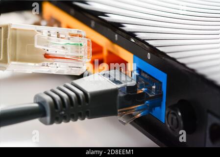 Internet-Router für Zuhause mit drei Kabeln mit RJ-45-Anschlüssen, Internetverbindung. Konzept Heimnetzwerk, Nahaufnahme. Stockfoto