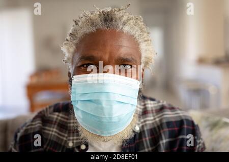 Porträt eines älteren Mannes mit Gesichtsmaske zu Hause Stockfoto