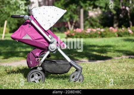 Baby Kinderwagen mit Sommer-Kit ist auf grner Wiese im Sommer sonnigen  Park, Vorderansicht, Sugling perambulator Serie Stockfotografie - Alamy