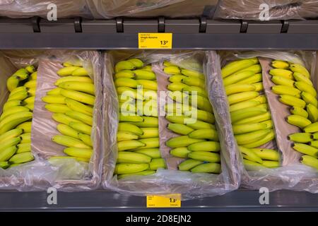 Offene Kartons mit Bananen zum Verkauf in einem Supermarkt in Cardiff, Wales, Vereinigtes Königreich. Stockfoto