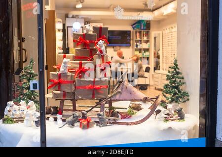 HELSINKI, FINNLAND-CIRCA DEZ, 2018: Dekoriert mit Mäusen, Schlitten und Geschenkboxen Schaufenster eines kleinen Brillen-Ladens. Traditionelle Weihnachtsdekorationen Stockfoto