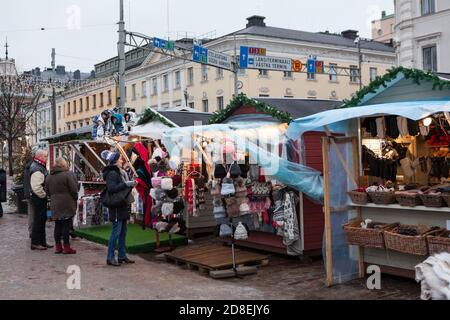 HELSINKI, FINNLAND-CIRCA DEZ, 2018: Holzstände für den Verkauf von Kleidung und Souvenirs befinden sich am städtischen Pier. Traditioneller Weihnachtsmarkt mit Sachen, Essen und Stockfoto