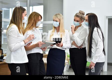 Weibliche Büroleiter tragen Gesichtsmasken bei einem Meeting in Das Büro Stockfoto
