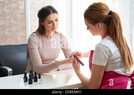 Oung Frau tut Maniküre im Salon. Schönheitskonzept. Stockfoto