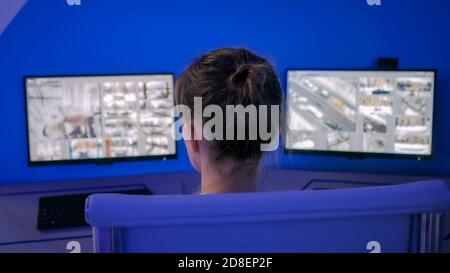 Überwachung, moderne Technik, Kontrolle, Sicherheit von Privateigentum Konzept. Frau Wachmann Blick auf moderne cctv-Kamera-Monitore in der Dunkelheit Stockfoto