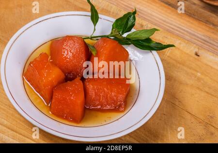 Nahaufnahme eines weißen Gerichts mit einem hausgemachten Dessert Hergestellt aus Scheiben einer tropischen Frucht bekannt als Papaya Stockfoto