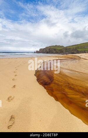 Der rote Fluss fließt hinunter zum Dalmore Strand am Isle of Lewis Stockfoto