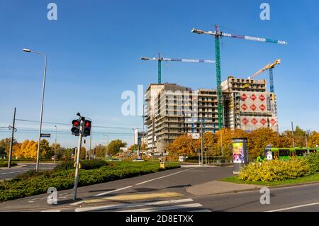 POZNAN, POLEN - 25. Okt 2020: Hochhaus im Bau neben hohen Kräne an einer Straße Stockfoto