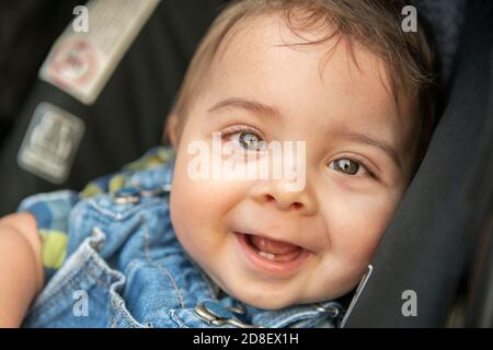 Nettes 9 Monate altes Baby im Auto Kindersitz Stockfoto