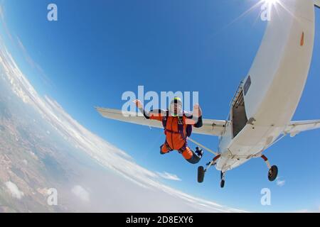 Alter Mann, der einen Traum verwirklicht und aus einem Flugzeug springt Stockfoto