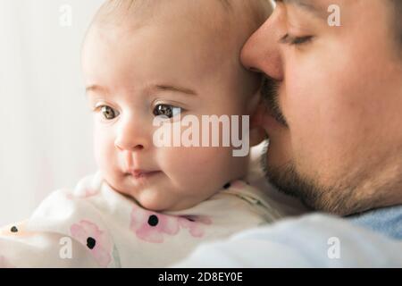 Junger Papa mit seiner Tochter in den Armen auf dem Babyzimmer Stockfoto