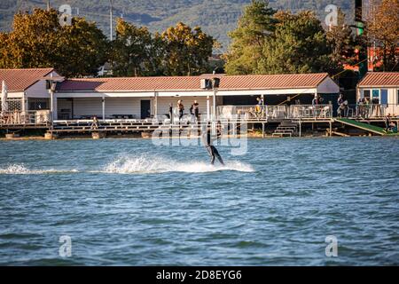 Mann wird auf einem Wakeboard auf einem See gezogen Stockfoto