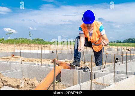 Verlegung von Kunststoffrohren auf das Fundament des Gebäudes Stockfoto