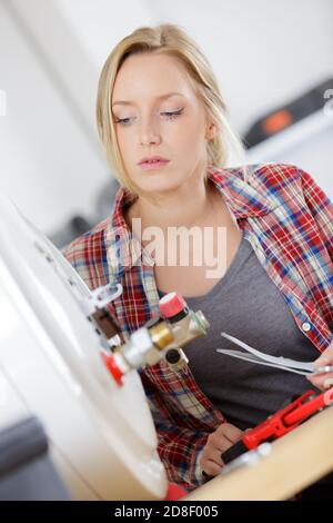 Weibliche Klempner Arbeiten an zentralen Heizkessel Stockfoto