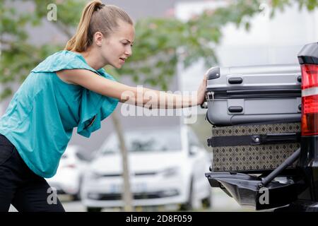 Frau schob ihre Taschen in das Autofach Stockfoto