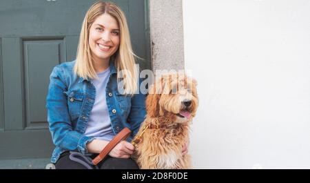 Labradoodle Hund und Frau draußen auf dem Balkon Stockfoto