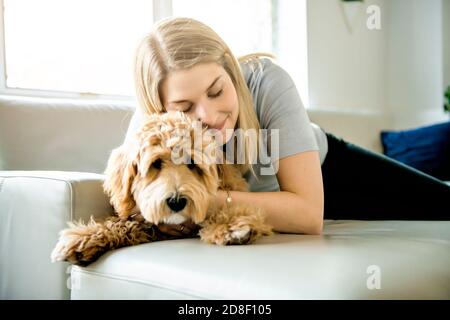 Frau mit seinem Golden Labradoodle Hund zu Hause Stockfoto