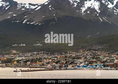 Ushuaia, Feuerland, Argentinien - 13. Dezember 2008: Dämmerung über Pier und Stadt mit vielen kleineren Booten auf Silberwasser. Stadtbild gegen Hintern Stockfoto