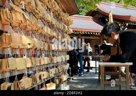 Besucher, die Wünsche auf hölzernen ema (Wish Plaques) am Meiji Jingu Schrein, Shibuya.Tokyo, Japan schreiben Stockfoto