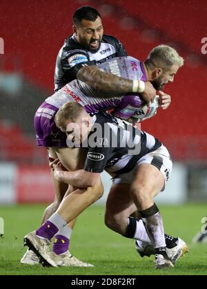 Hull KR's Ben Crooks (Mitte) wird während des Betfred Super League Spiels im total Wicked Stadium, St. Helens, von der Hull FC Verteidigung gestoppt. Stockfoto