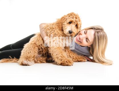 Frau mit seinem Golden Labradoodle Hund isoliert auf weißem Hintergrund Stockfoto