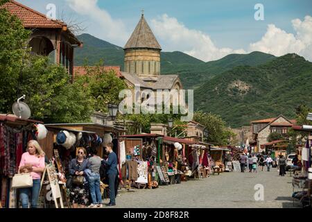 Historische Kathedrale Svetizchoweli erhebt sich über einer Straße mit Souvenirläden in Mzcheta, Georgien, Kaukasus, Osteuropa gesäumt. Stockfoto