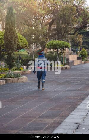 Mann im öffentlichen Dienst Reinigung Müll im Stadtpark - Mann mit Besen und Reinigungsanzug im Colonial Park früh am Morgen - Quetzaltenang Stockfoto