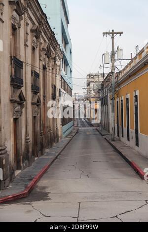 Enge leere Straße der Kolonialstadt am frühen Morgen An einem bewölkten Tag - Straße des historischen Zentrums von Quetzaltenango Guatemala Stockfoto