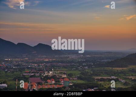 Dieses einzigartige Foto zeigt den Sonnenuntergang Ende Oktober über der thailändischen Küstenstadt Hua hin. Sie können die Häuser und Berge sehr gut sehen. Stockfoto