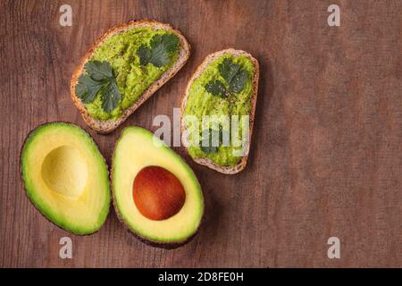 Gesunde Ernährung Hintergrund mit frischen Avocado und Guacamole Sauce auf alten Holztisch, Draufsicht, Kopierraum Stockfoto