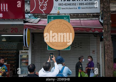 Bangkok, Thailand. Okt. 2020. Die Menschen machen ein Foto von der Plakette der Volkspartei, die Demonstranten während der Demonstration auf dem Verkehrsschild angebracht hatten.Tausende von prodemokratischen Demonstranten gingen in Silom auf die Straße und forderten den Rücktritt des thailändischen Premierministers und die Reform der Monarchie. Der Protest wurde von der Free Youth Group unter dem Motto „People's Runway“ organisiert, mit einem modischen 'roten Teppich', Tanz, Performance, Show und Musik. Kredit: SOPA Images Limited/Alamy Live Nachrichten Stockfoto