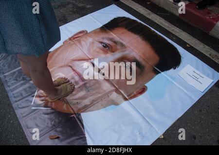 Bangkok, Thailand. Okt. 2020. Ein Protestler steht auf einem Plakat mit einem Foto des thailändischen Ministerpräsidenten Prayut Chan-o-cha während der Demonstrationen.Tausende von prodemokratischen Demonstranten gingen in Silom auf die Straße und forderten den Rücktritt des thailändischen Ministerpräsidenten und die Reform der Monarchie. Der Protest wurde von der Free Youth Group unter dem Motto „People's Runway“ organisiert, mit einem modischen 'roten Teppich', Tanz, Performance, Show und Musik. Kredit: SOPA Images Limited/Alamy Live Nachrichten Stockfoto