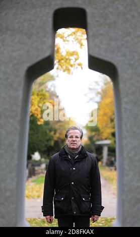 Köln, Deutschland. Oktober 2020. Christoph Kuckelkorn, Begräbnisdirektor und Karnevalspräsident, steht hinter einer Skulptur auf dem Melatenfriedhof. (An dpa 'mit Faschingspräsident Christoph Kuckelkorn im Melatenfriedhof') Quelle: Oliver Berg/dpa/Alamy Live News Stockfoto