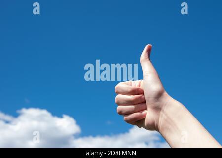 Geste, Daumen nach oben auf einem Hintergrund von blauen Himmel und Wolken, kopieren Raum. Motivation bei der Arbeit Konzept, Geschäftskonzept Stockfoto