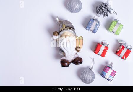 Weihnachtskomposition, Weihnachtsmann oder Kobold, Weihnachtsgeschenke, Silberkugeln und Tannenzapfen auf weißem Hintergrund Stockfoto