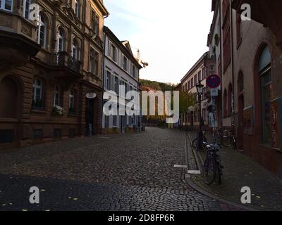 Freiburg, Baden-Württemberg, Deutschland - 10/25/2020: Leere Seitenstraße am Sonntagmorgen in der Freiburger Altstadt mit Fahrrädern an Straßenschild gebunden. Stockfoto