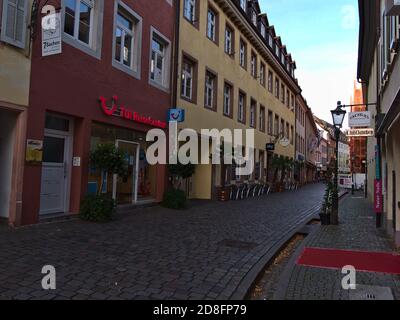 Freiburg, Baden-Württemberg, Deutschland - 10/25/2020: Verlassene schmale Einkaufsstraße mit geschlossenem TUI Reisebüro und Cafe in der Altstadt. Stockfoto