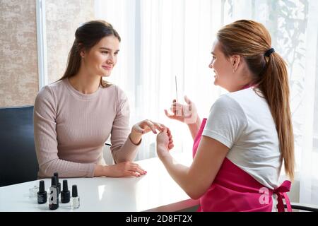 Oung Frau tut Maniküre im Salon. Schönheitskonzept. Stockfoto