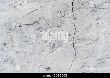 Risse in der alten verputzten Wand. Abstrakter Hintergrund Stockfoto