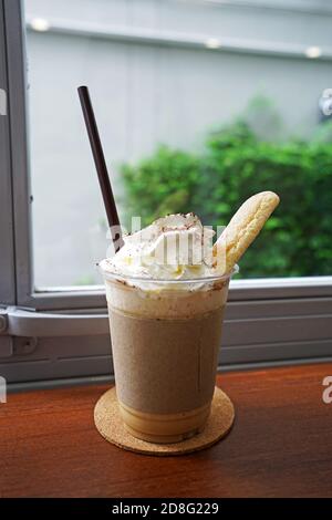 Nahaufnahme Kunststoff nehmen Tasse Kaffee Latte Smoothies Auf mit Schlagsahne und kurzem Brot serviert auf gekrönt Holztablett Tisch Stockfoto
