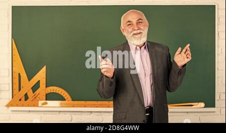 Prozess für jede Lösung. Bärtiger Dozent Mann erklären Geometrie. Zurück zur Schule. Mathematische grafische Werkzeuge. trigonometrie Lektion im Klassenzimmer. Holen Sie sich Wissen hier. Senior Mann Lehrer verwenden mathematische Werkzeuge. Stockfoto